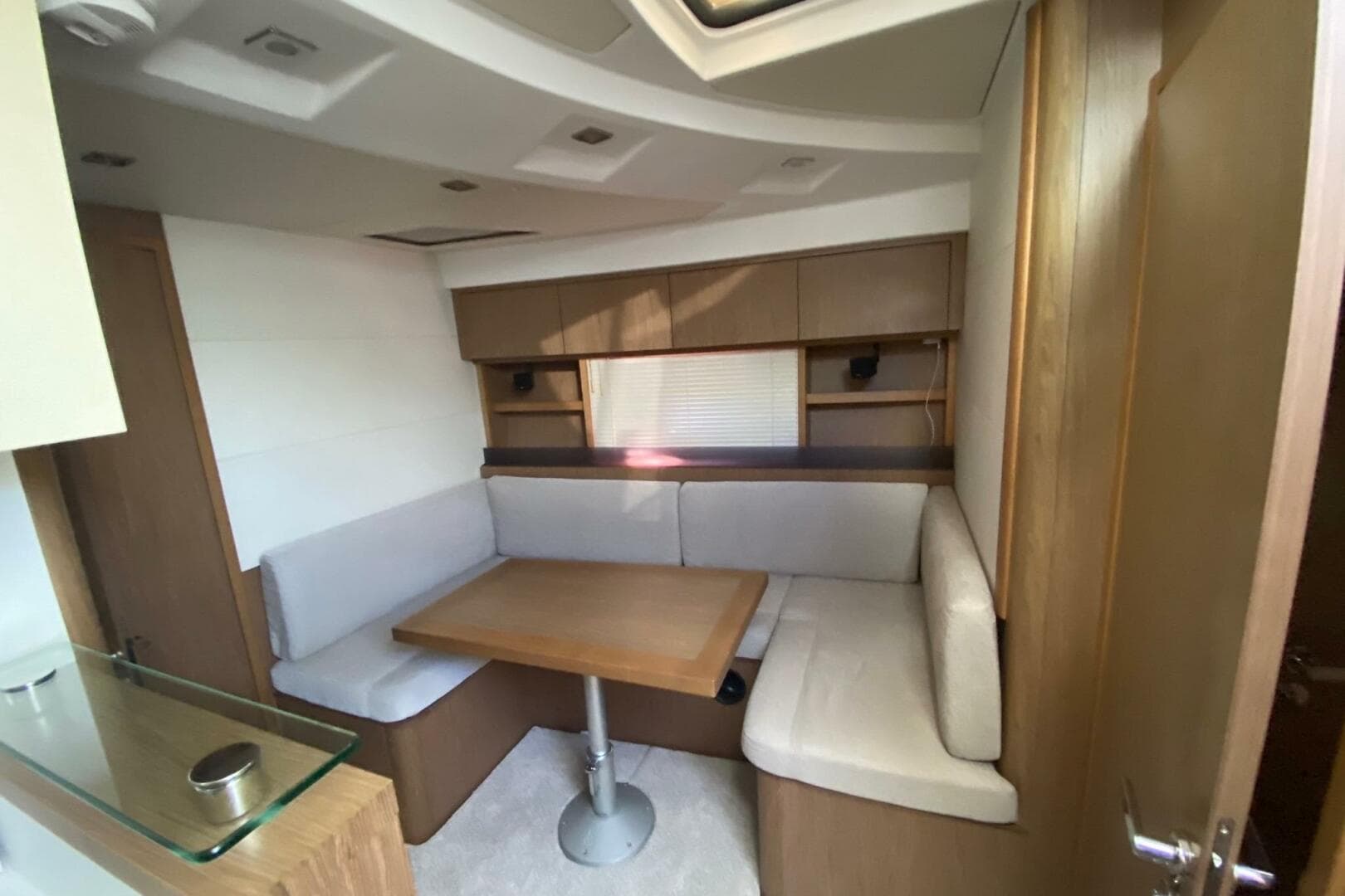2014 Beneteau Gran Turismo 44 interior with cozy dining area and wooden cabinetry.
