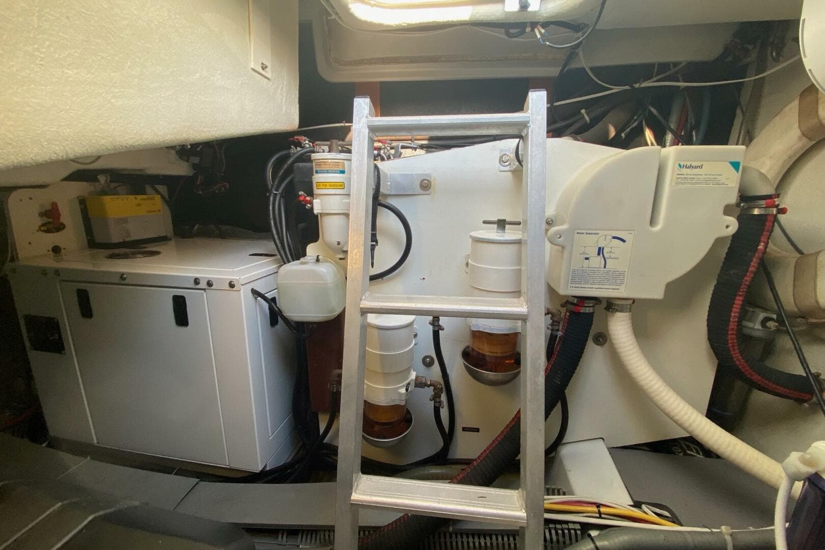 Engine room of a 2014 Beneteau Gran Turismo 44 with visible machinery and ladder.