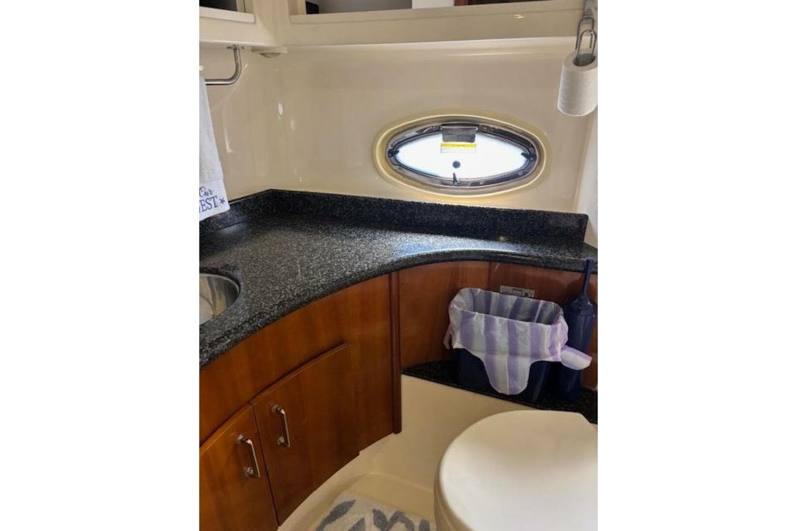 Luxurious bathroom in 2004 Carver 466 Motor Yacht with granite countertop and oval window.