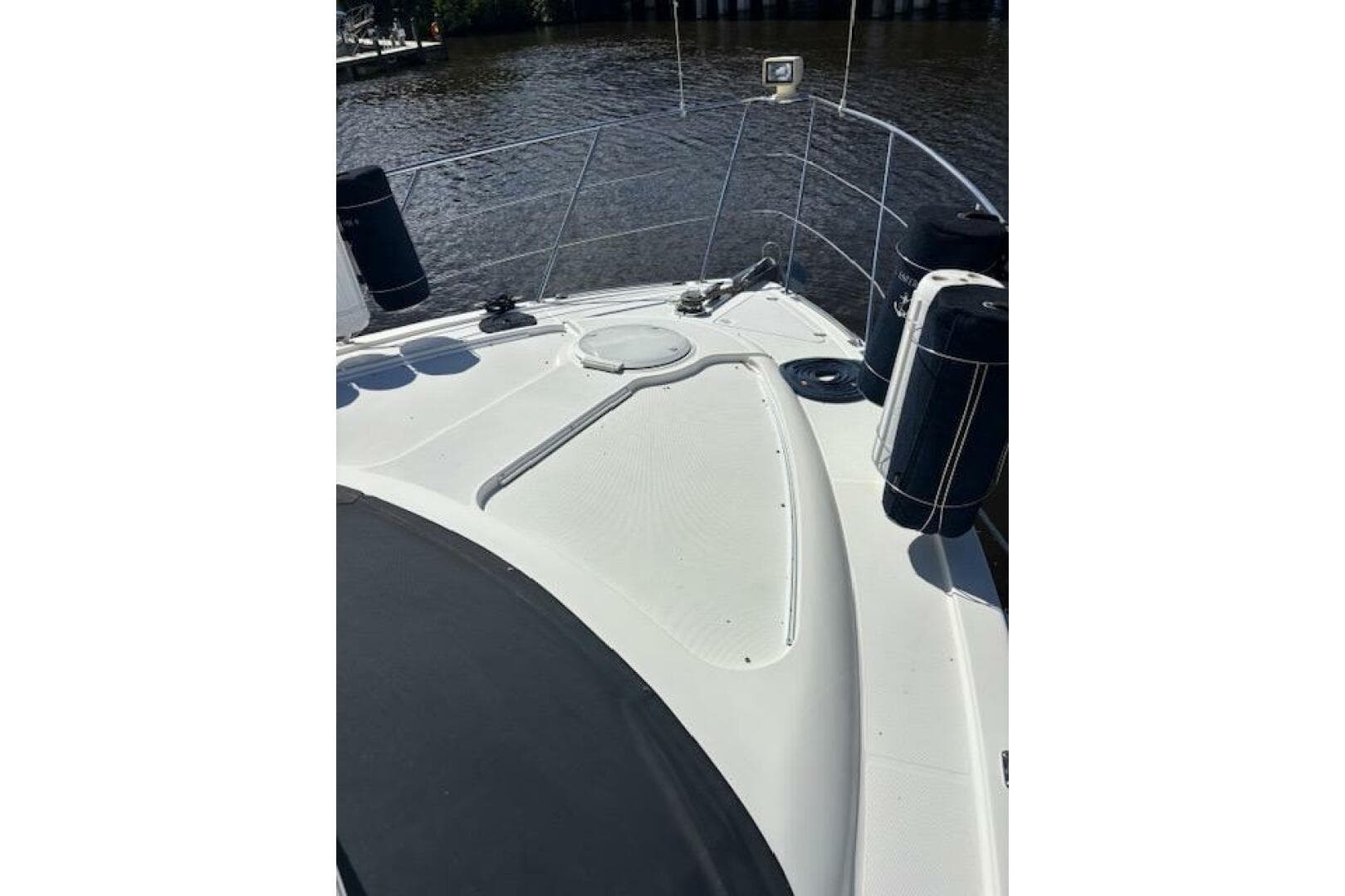 2004 Carver 466 Motor Yacht deck with railing and fenders on a sunny day.