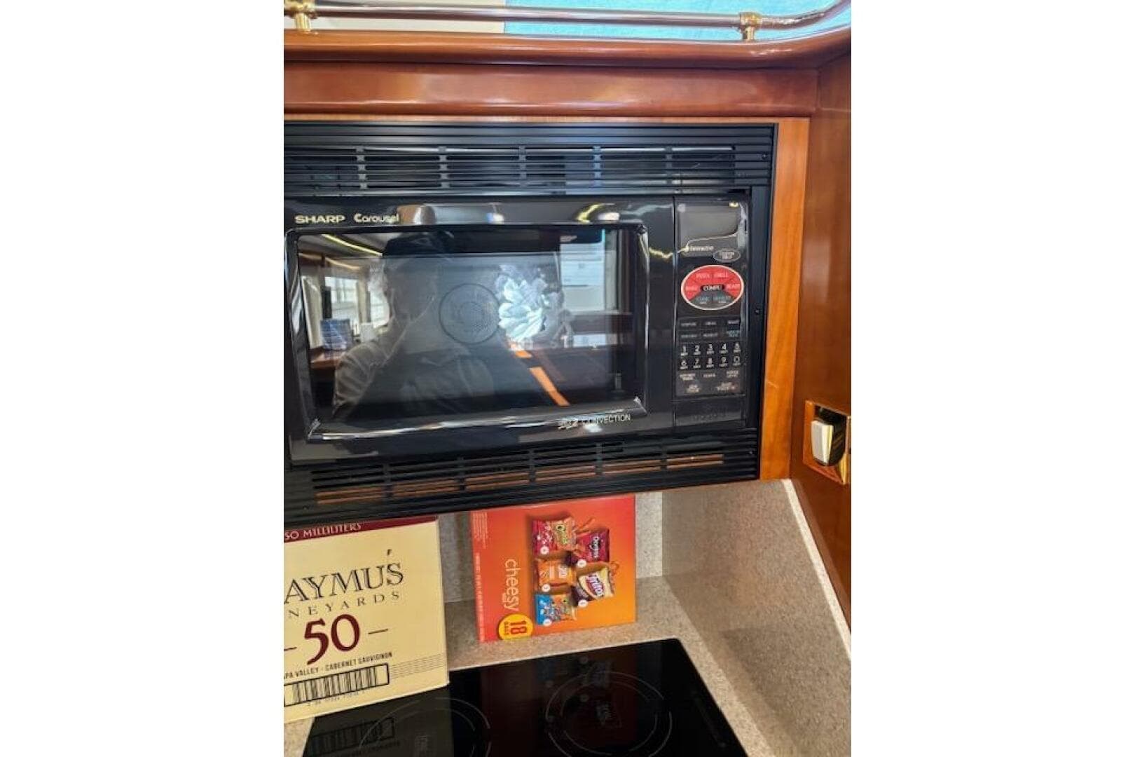Microwave in 2004 Carver 466 Motor Yacht kitchen with snacks and wine box nearby.