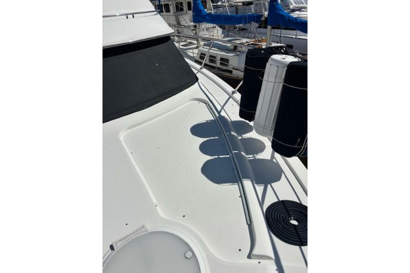 2004 Carver 466 Motor Yacht deck with fenders and railing in marina.