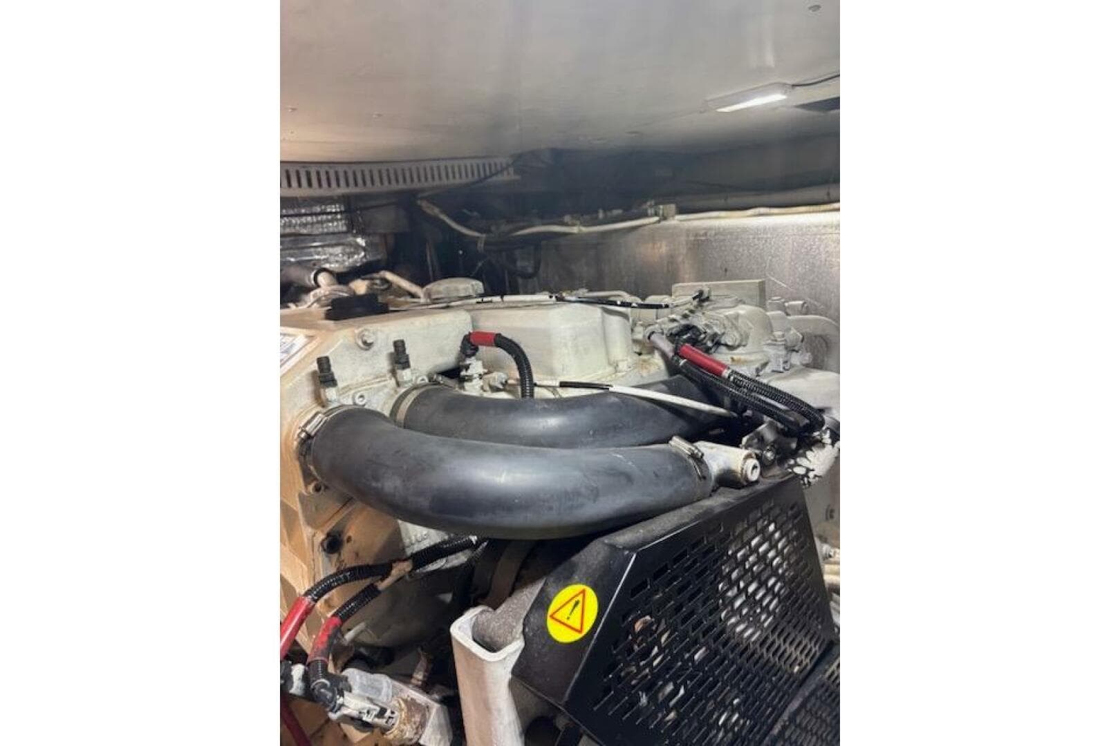 Engine compartment of a 2004 Carver 466 Motor Yacht, featuring hoses and mechanical components.