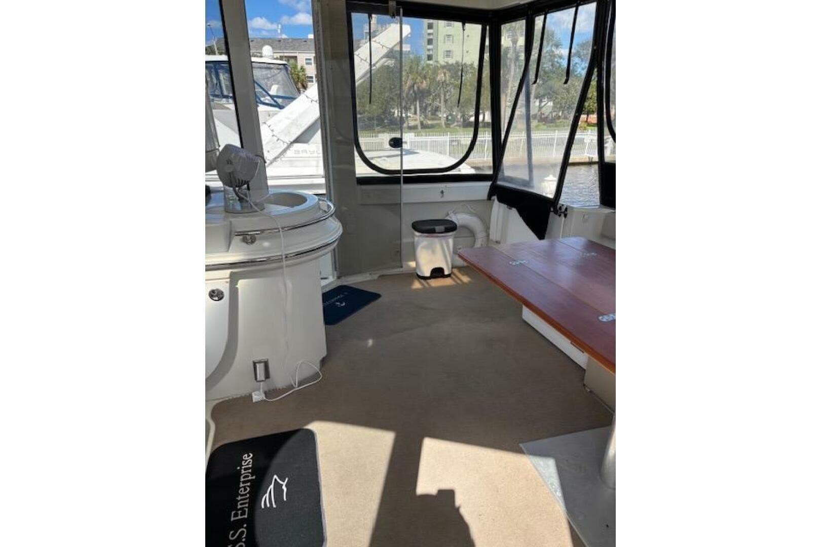 Interior of 2004 Carver 466 Motor Yacht with seating and windows, docked by water.