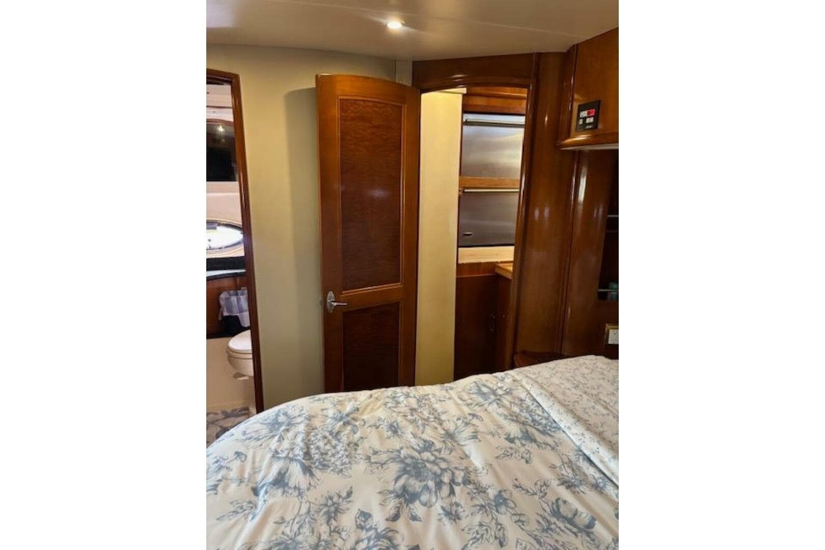 Interior of 2004 Carver 466 Motor Yacht bedroom with wooden cabinetry and floral bedding.