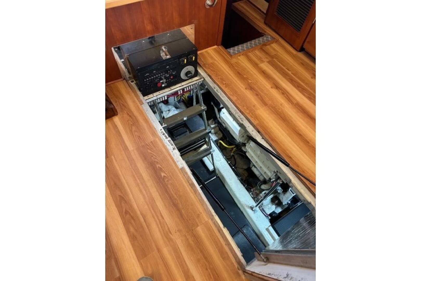 Engine compartment of 2004 Carver 466 Motor Yacht with wooden flooring.