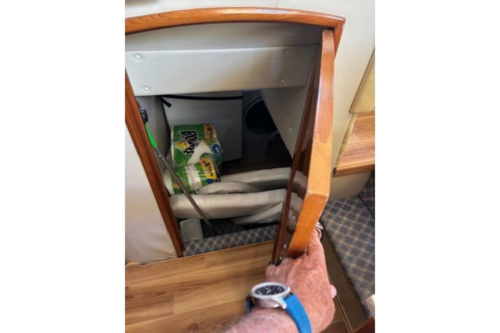 Storage compartment in 2004 Carver 466 Motor Yacht with cleaning supplies and equipment.