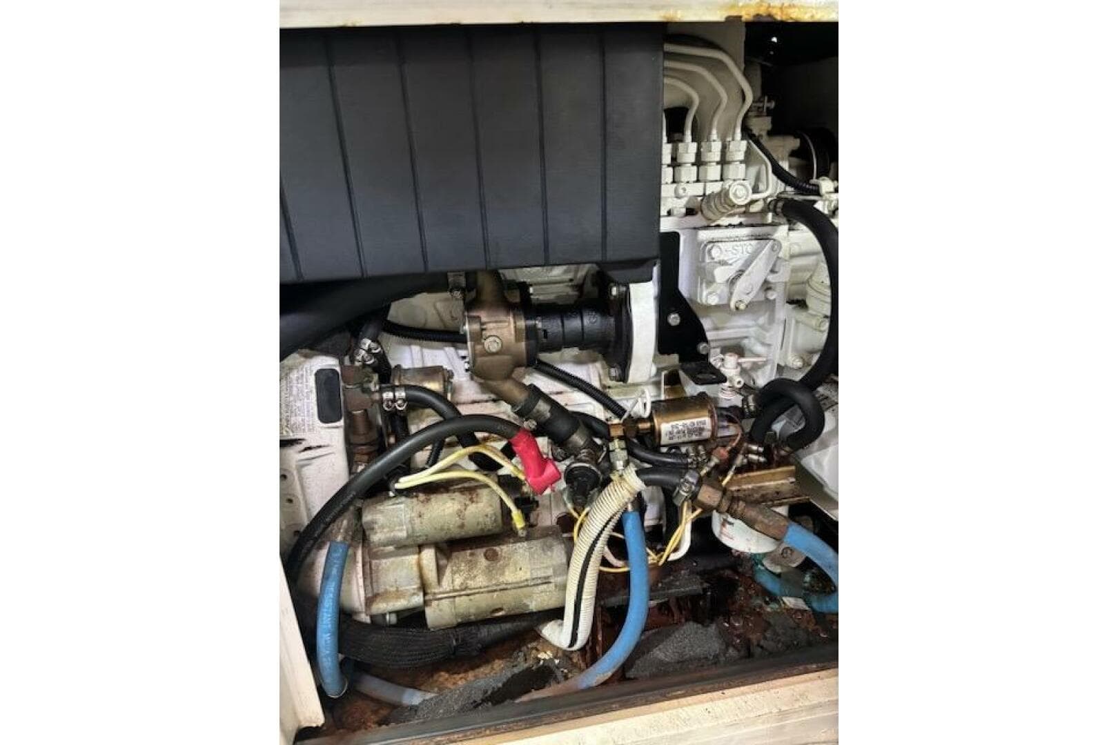 Engine compartment of a 2004 Carver 466 Motor Yacht, showcasing mechanical components and hoses.