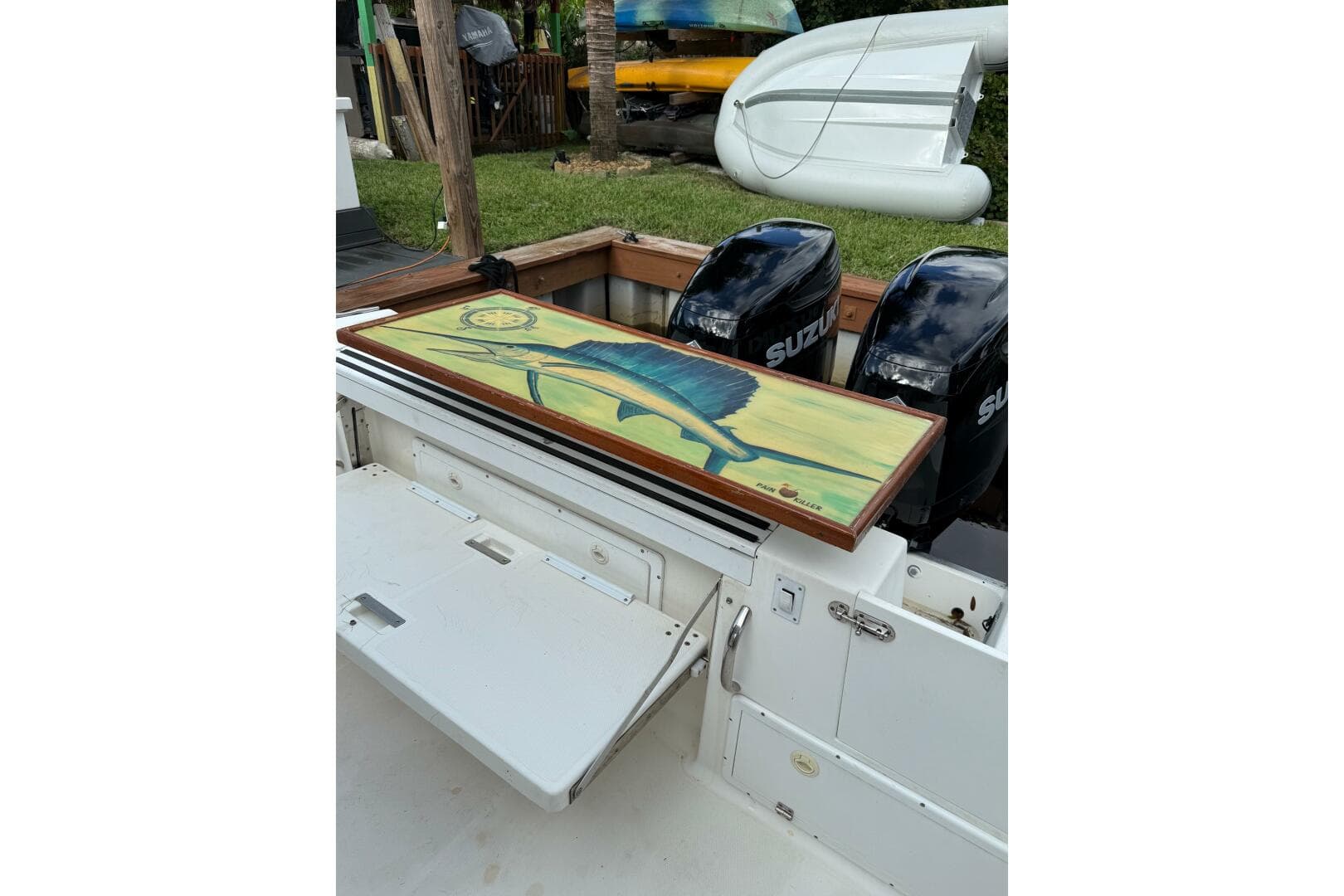 2002 Wellcraft 290 Coastal boat with Suzuki engines and fish artwork on deck.