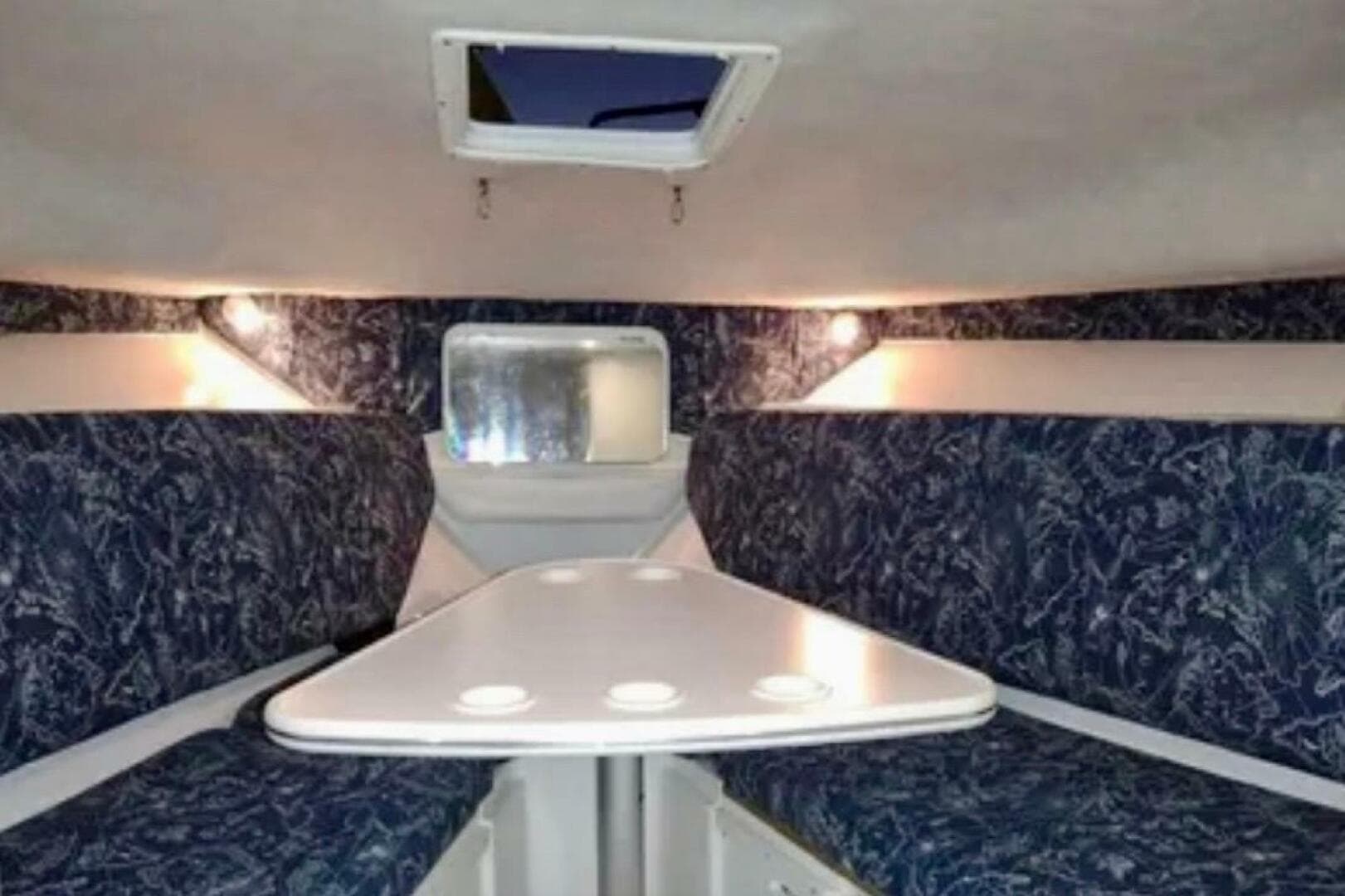 2002 Wellcraft 290 Coastal cabin interior with seating and table.