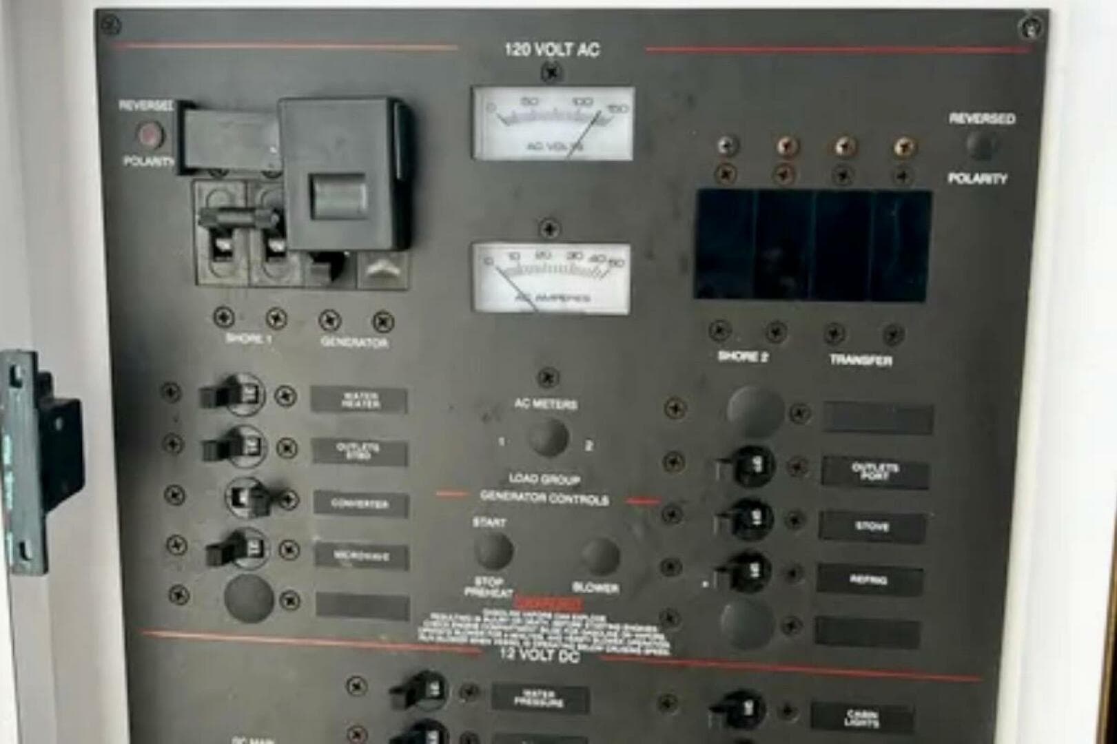 Electrical control panel on a 2002 Wellcraft 290 Coastal boat, featuring various switches and meters.