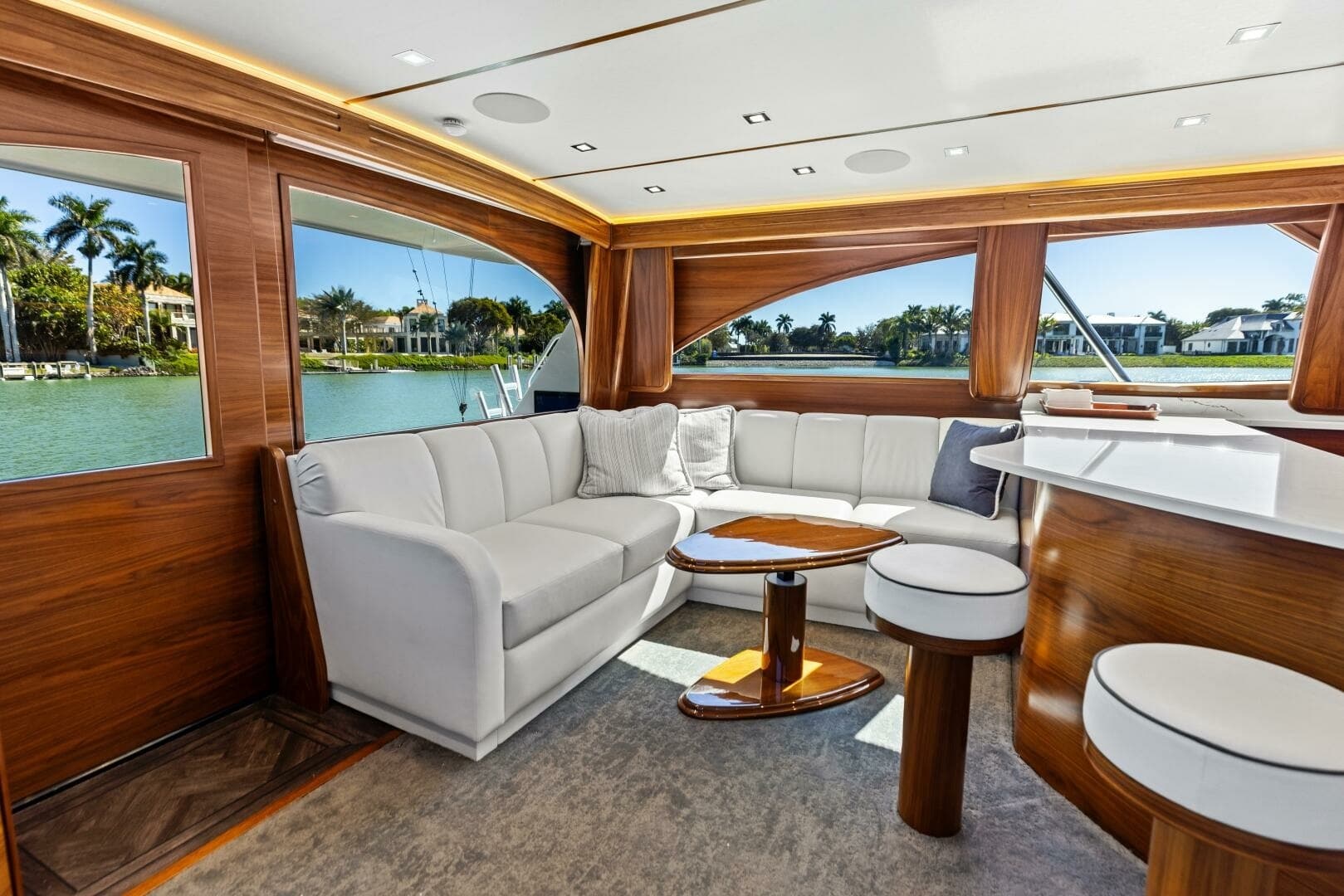 2023 Viking 54 Convertible "Olde Floridian" - A Salon Featuring Plush Seating that Invites Relaxation, Complemented by Rich Wood Finishes and Expansive Windows Offering Stunning Panoramic Water Views